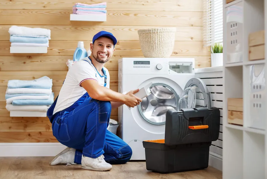 Appliance technician beside a washing machine