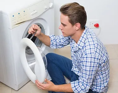Technician inspecting a washing machine door